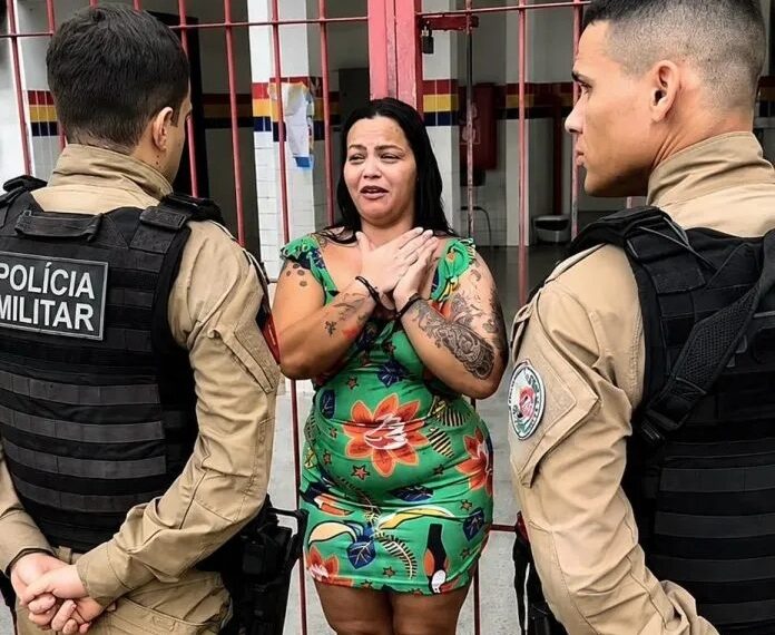Mãe de aluno com TEA protesta com as mãos amarradas em frente a escola, no Bairro do Novais